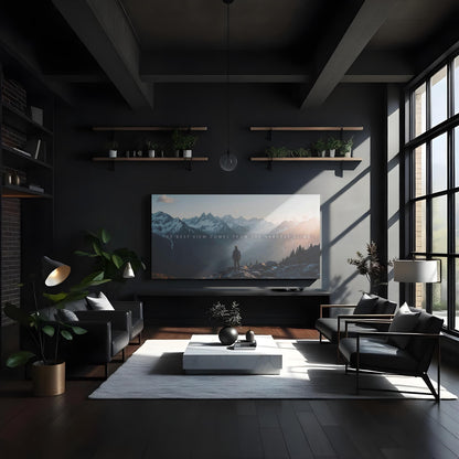 A high-end modern living room with floor-to-ceiling windows, sleek black furniture, and warm wood tones. A massive adventure-themed canvas print hangs above the entertainment unit, featuring a hiker overlooking a stunning mountain view at sunrise. Floating shelves with plants add a natural touch, while the quote &quot;The best view comes from the hardest climb&quot; serves as a bold statement of perseverance and ambition.