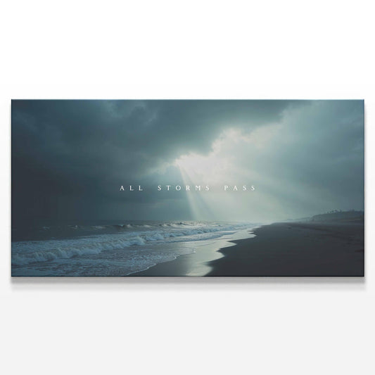 A canvas print of a stormy beach scene with dark clouds, ocean waves, and rays of sunlight breaking through. The words &quot;All Storms Pass&quot; are centered, creating a moody yet hopeful atmosphere.