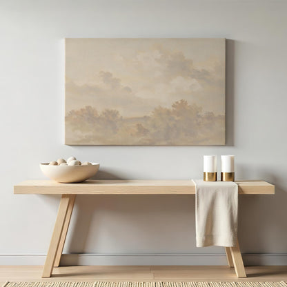 Neutral-toned landscape canvas art displayed above a minimalist wooden console table. Styled with a ceramic bowl, decorative stones, gold-accented candles, and a beige linen cloth for a warm, modern aesthetic.