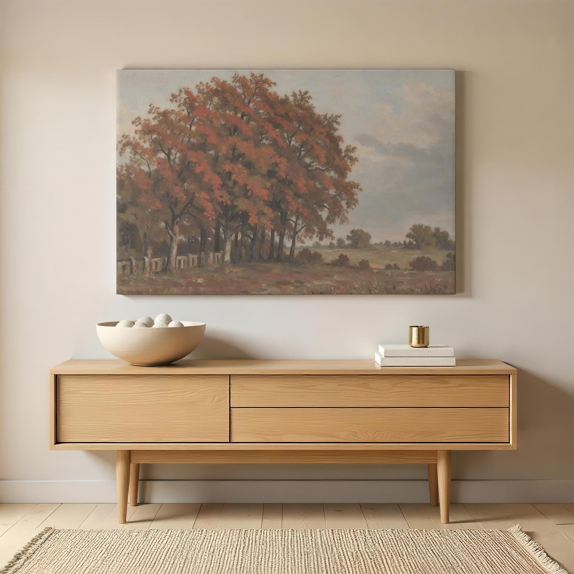Autumn landscape canvas wall art displayed above a mid-century modern wooden sideboard. Styled with a ceramic bowl, gold-accented decor, and neutral elements for a warm, inviting space.