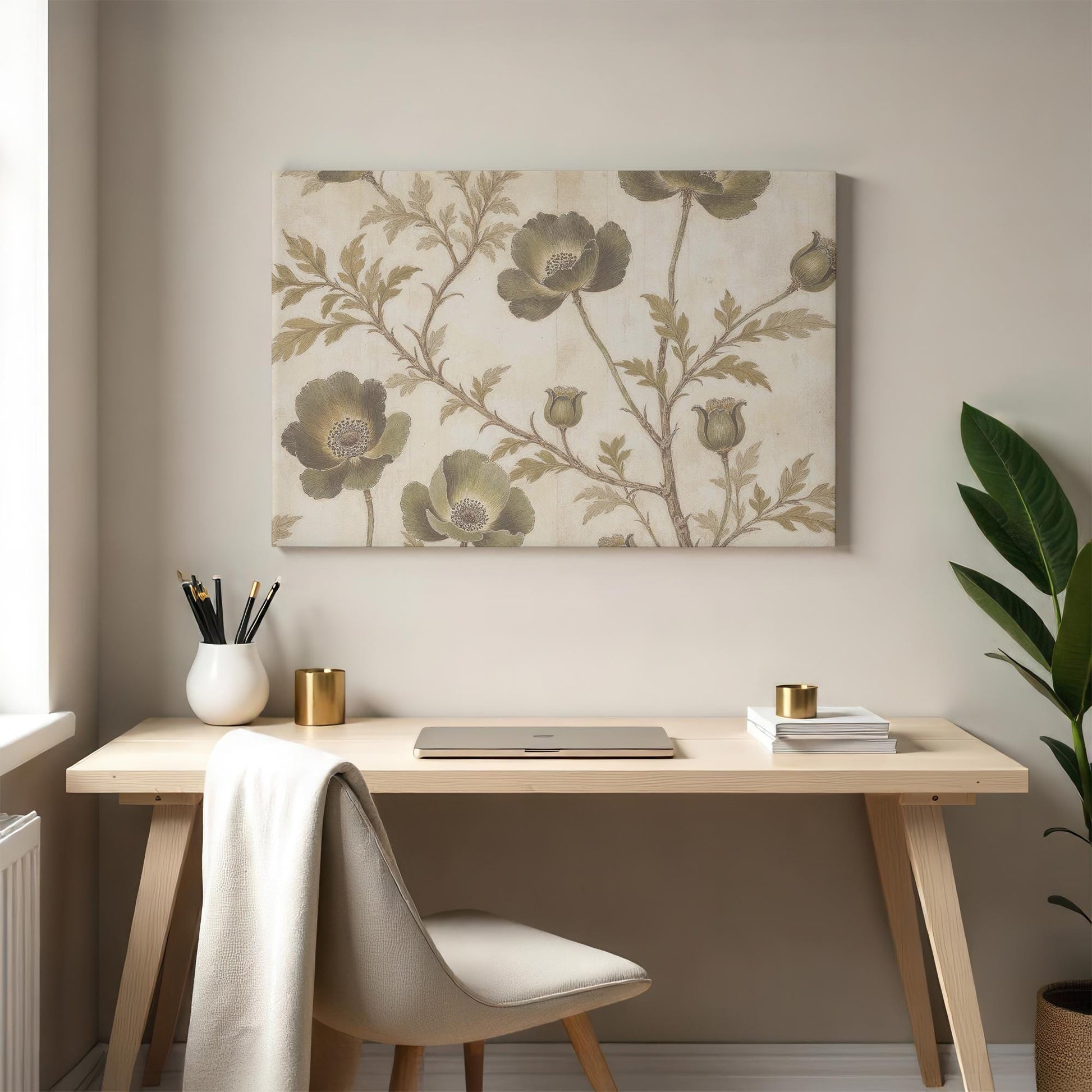 botanical canvas print with delicate green flowers and soft neutral hues adorns the wall above a wooden desk. The workspace is decorated with a minimalist white vase, gold accents, and a green houseplant, enhancing the elegant aesthetic.