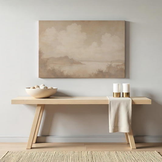 Large neutral-toned landscape canvas wall art featuring soft clouds and a serene lake scene, perfect for minimal and modern decor. Displayed above a wooden console table with neutral home accents.