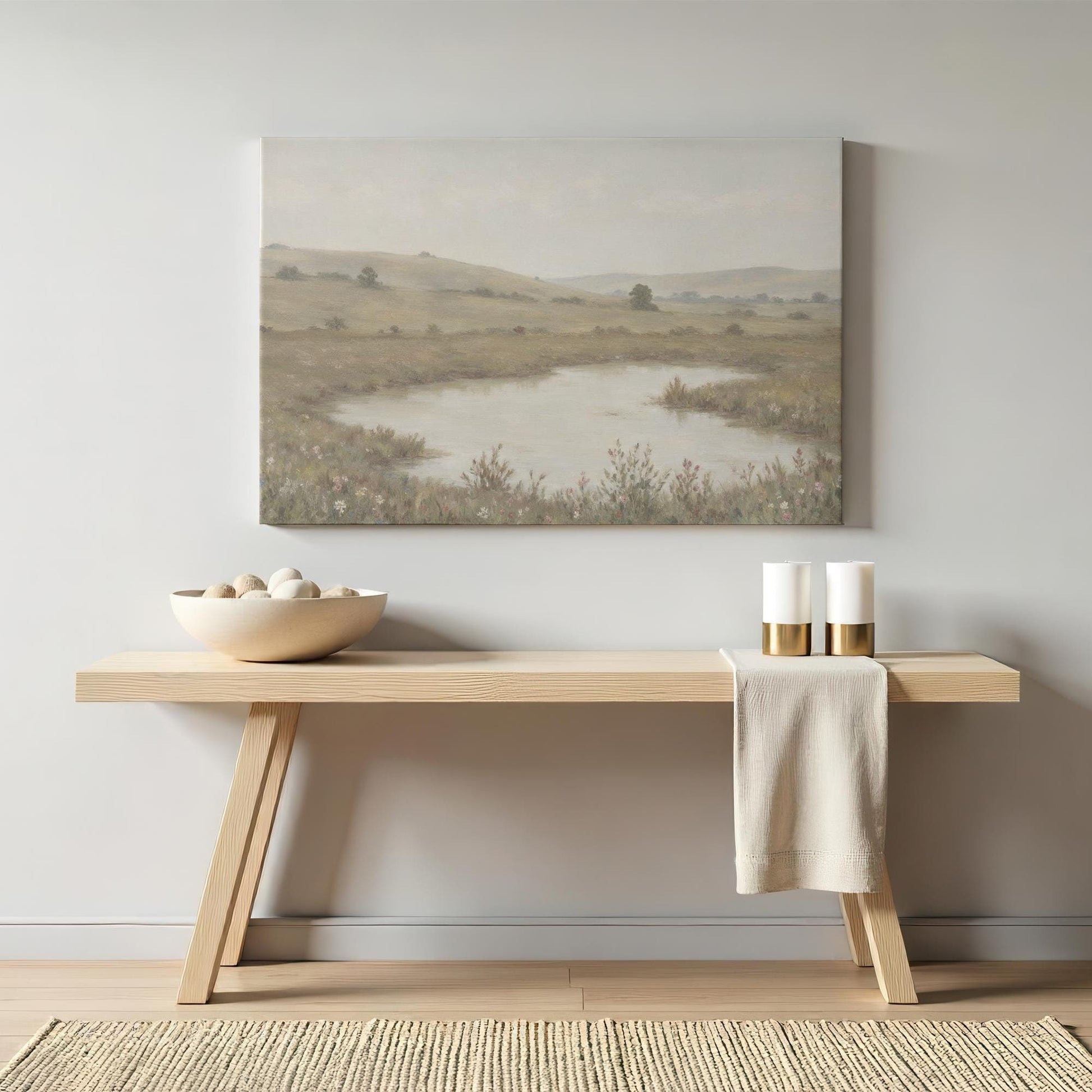 Elegant neutral-toned wall art of a countryside landscape above a modern wooden console table with minimalist decor. A timeless nature painting that adds warmth and tranquility to hallways or living spaces.