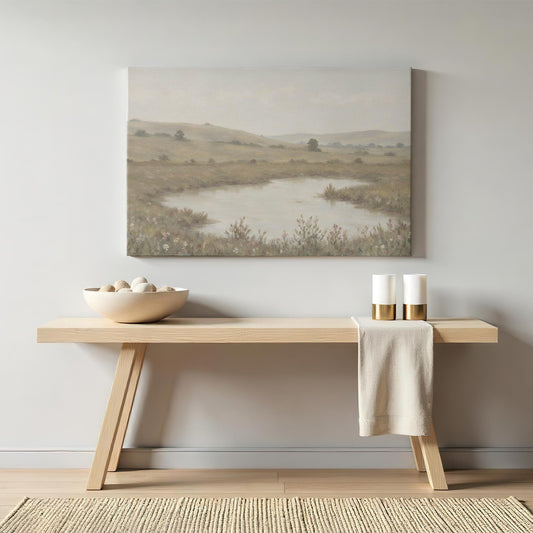 Elegant neutral-toned wall art of a countryside landscape above a modern wooden console table with minimalist decor. A timeless nature painting that adds warmth and tranquility to hallways or living spaces.