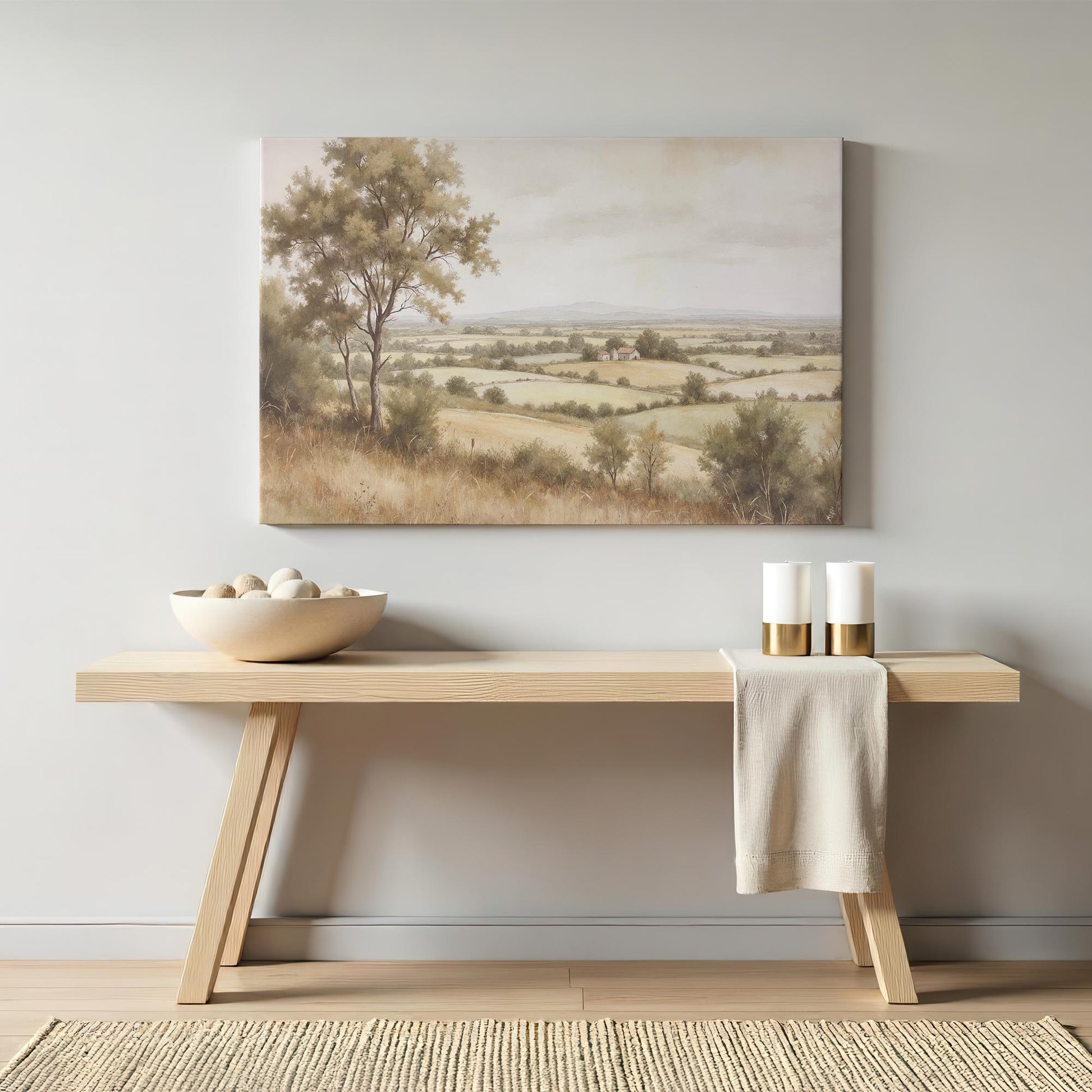 Rustic countryside canvas wall art above a modern wooden console table with neutral decor. Serene farmhouse-style wall decor for a living room, hallway, or entryway. Large wall art for home and office decor.