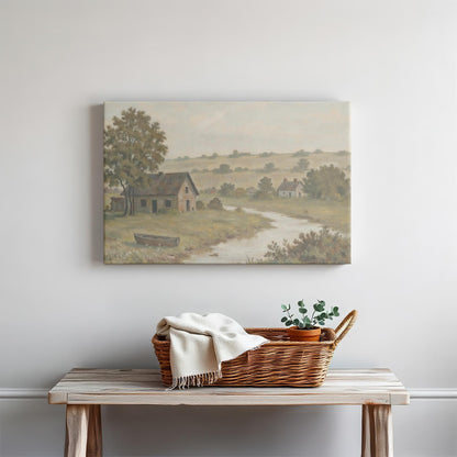 A farmhouse-style console table with a woven basket, blanket, and potted greenery, set against a soft neutral wall with a countryside landscape canvas of a river, rustic home, and rolling hills, creating a cozy, welcoming space.