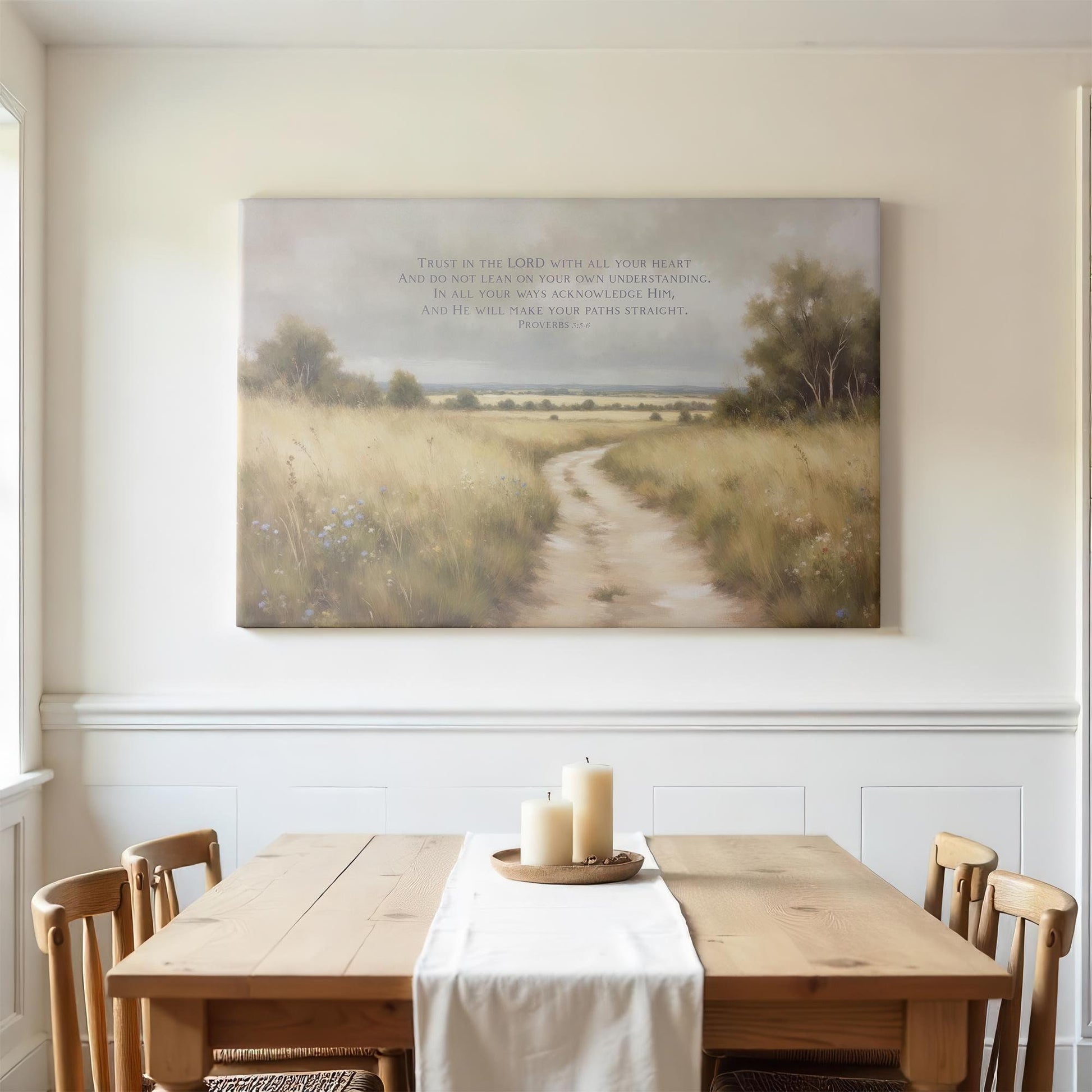 Bright dining room with a wooden table and soft natural light. A large canvas print of Proverbs 3:5-6 depicting a peaceful path through a golden field adds a calming, inspirational touch to the room.