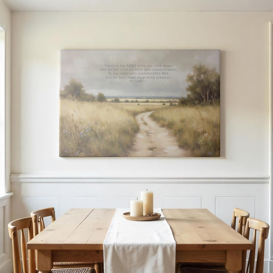 Bright dining room with a wooden table and soft natural light. A large canvas print of Proverbs 3:5-6 depicting a peaceful path through a golden field adds a calming, inspirational touch to the room.