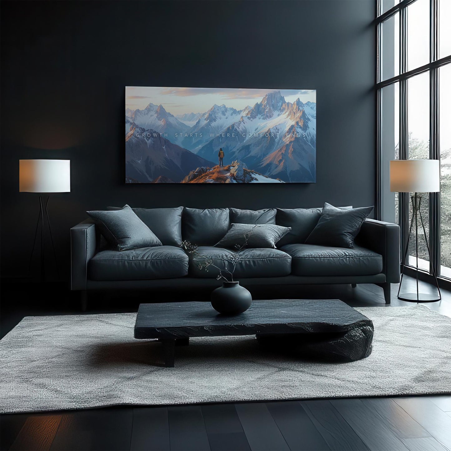 A cozy living room with a dark leather couch and a minimalistic black coffee table. A mountain canvas is prominently displayed on the wall, showcasing an adventurous scene with golden and blue tones. Natural light pours in from large windows.