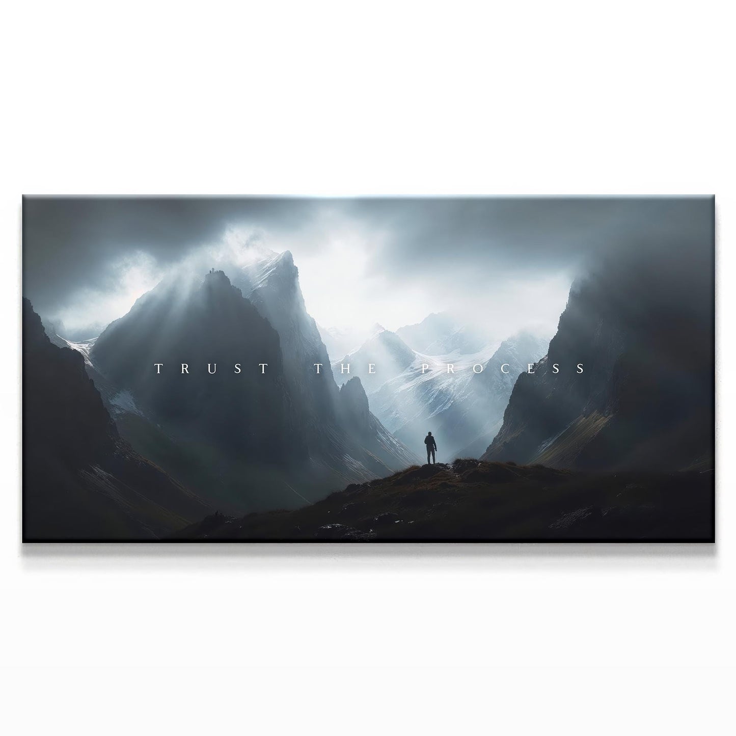 A majestic mountainous landscape with a figure standing in the distance beneath dramatic clouds. The text &quot;TRUST THE PROCESS&quot; is centered in a minimalist white font, creating an inspiring and bold contrast with the dark, moody sky.