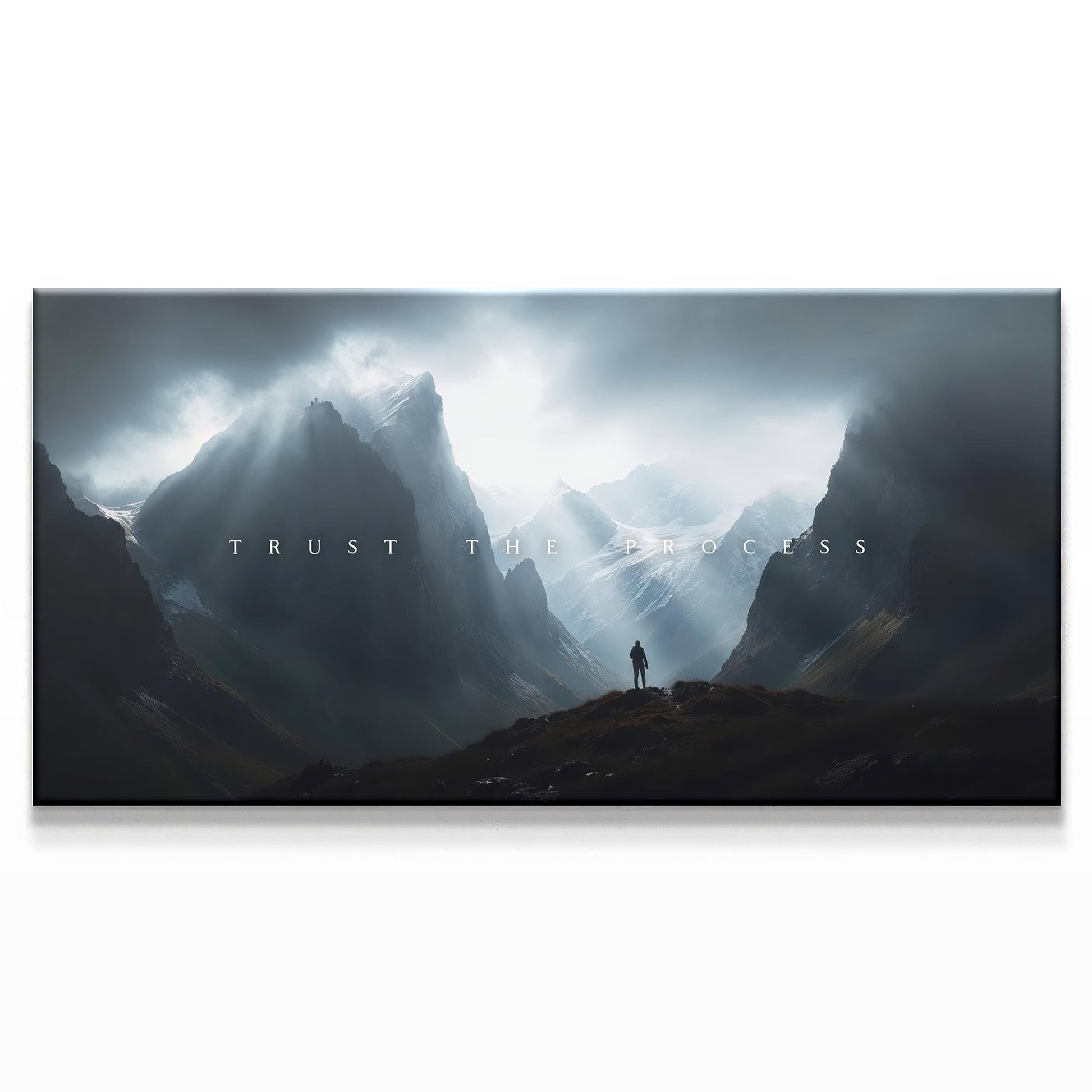 A majestic mountainous landscape with a figure standing in the distance beneath dramatic clouds. The text &quot;TRUST THE PROCESS&quot; is centered in a minimalist white font, creating an inspiring and bold contrast with the dark, moody sky.