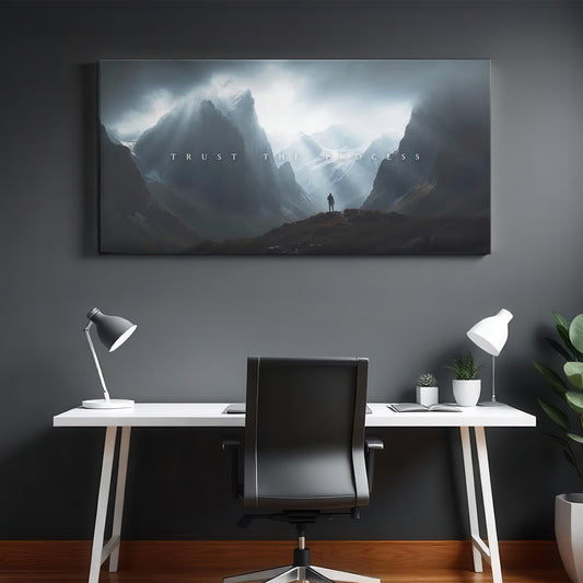 A modern office space with a clean desk, black chair, and lamps. The &quot;TRUST THE PROCESS&quot; canvas artwork hangs above the desk, bringing an element of inspiration to the sleek, contemporary environment.