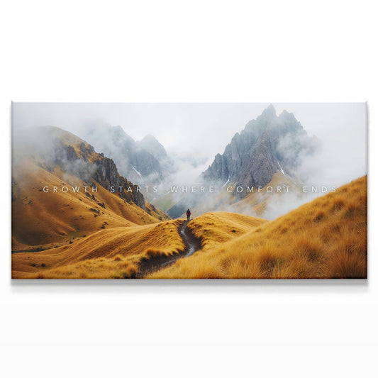A misty mountain landscape featuring golden grassy hills leading toward a distant jagged peak. A lone hiker stands on a winding path, with light clouds gently floating over the peaks, creating a peaceful yet adventurous scene.