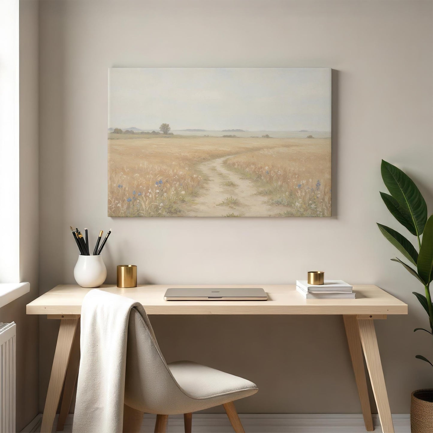 Modern workspace with a neutral-toned desk, white chair, and gold-accented decor. A serene wheat field landscape canvas hangs above, adding a calming nature-inspired touch to the office space.