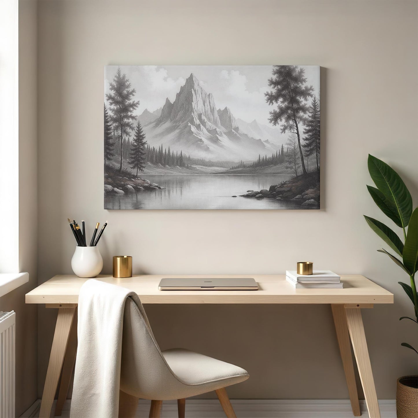 Black and white mountain landscape artwork hung above a stylish wooden desk with a cozy beige chair, elegant gold accents, and minimalist decor, perfect for a sophisticated and calming home office space.