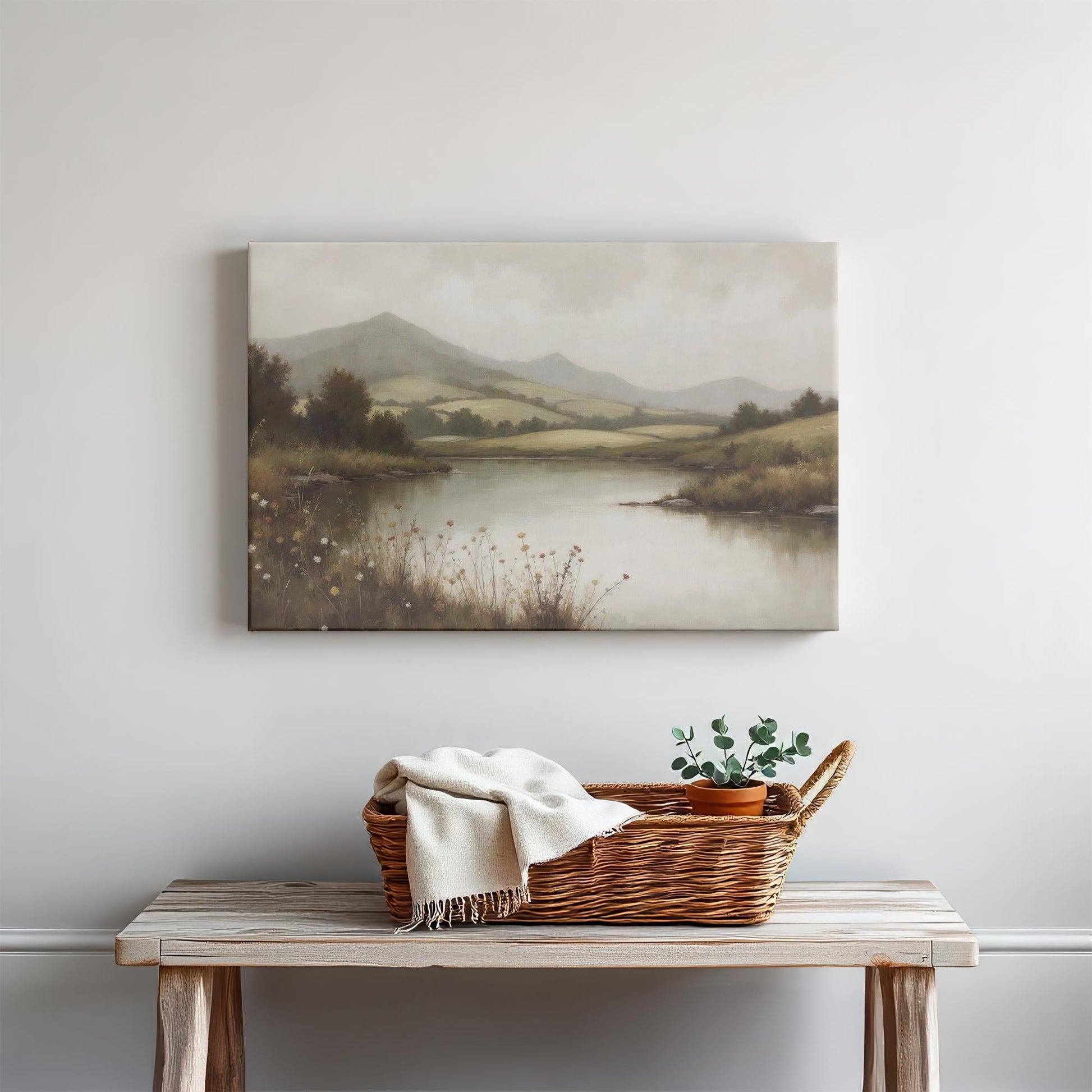 Vintage countryside landscape art on canvas above a rustic wooden bench. Styled with a woven basket, cozy throw, and potted plant, this nature wall art adds warmth and tranquility to farmhouse, minimalist, and Scandinavian-style interiors.