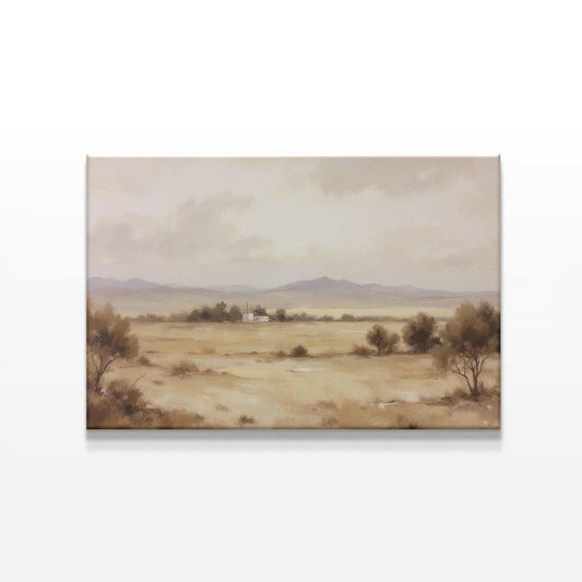 A large canvas featuring a peaceful beige-toned desert landscape with soft clouds and a rustic farmhouse in the distance, displayed on a white wall with subtle lighting for a calming aesthetic.