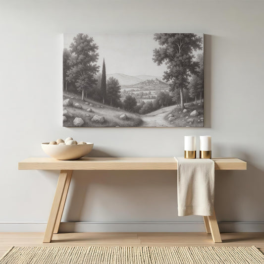 Minimalist entryway decor featuring a black and white landscape art piece above a light wood console table, styled with neutral ceramic bowls and candles.