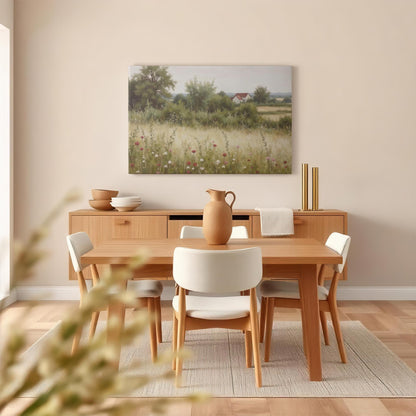 Vintage-inspired landscape canvas featuring a farmhouse and wildflower field, displayed in a cozy dining room with natural wood furniture, soft lighting, and neutral decor for a warm, inviting ambiance.