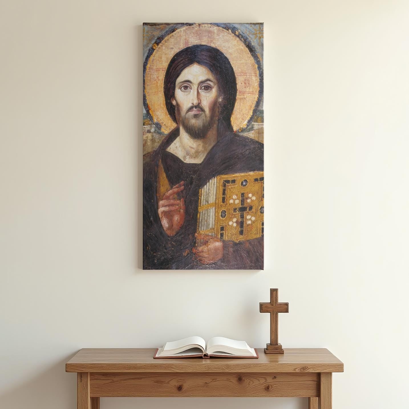 The Icon of Christ Pantocrator is mounted on a neutral-toned wall above a simple wooden prayer table. An open book and a standing wooden cross sit below, emphasizing a peaceful and minimal Orthodox home altar setup.