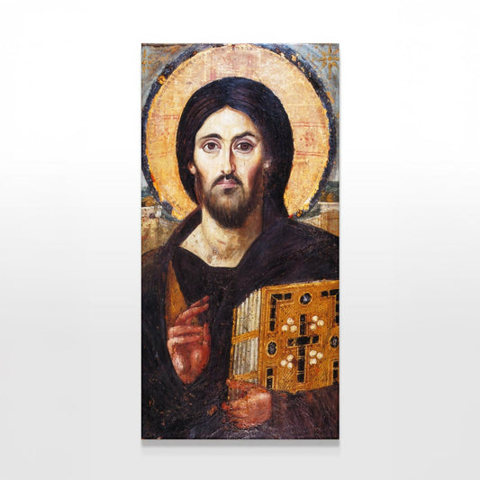 A tall canvas of the Icon of Christ Pantocrator is displayed against a plain white wall. The sacred icon features Christ holding the Gospel, His solemn gaze and golden halo illuminated by soft, even lighting, emphasizing its timeless beauty.