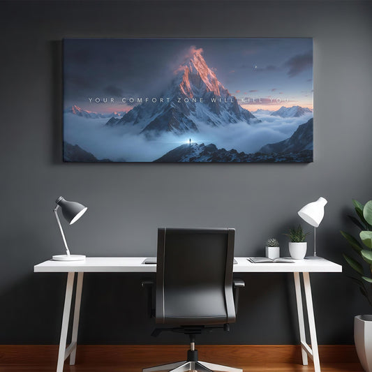 Modern home office with a sleek white desk, black chair, and soft lighting. A large canvas featuring a mountain scene with the words &quot;Your Comfort Zone Will Kill You&quot; hangs on the wall, creating an inspiring atmosphere.