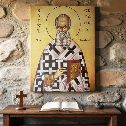 Orthodox icon of Saint Gregory the Theologian displayed above a rustic prayer table set against a stone wall. The saint wears detailed liturgical vestments and holds a Gospel book, symbolizing his role as a great teacher of the Church. A wooden cross and open Bible sit on the table, completing the devotional setting.