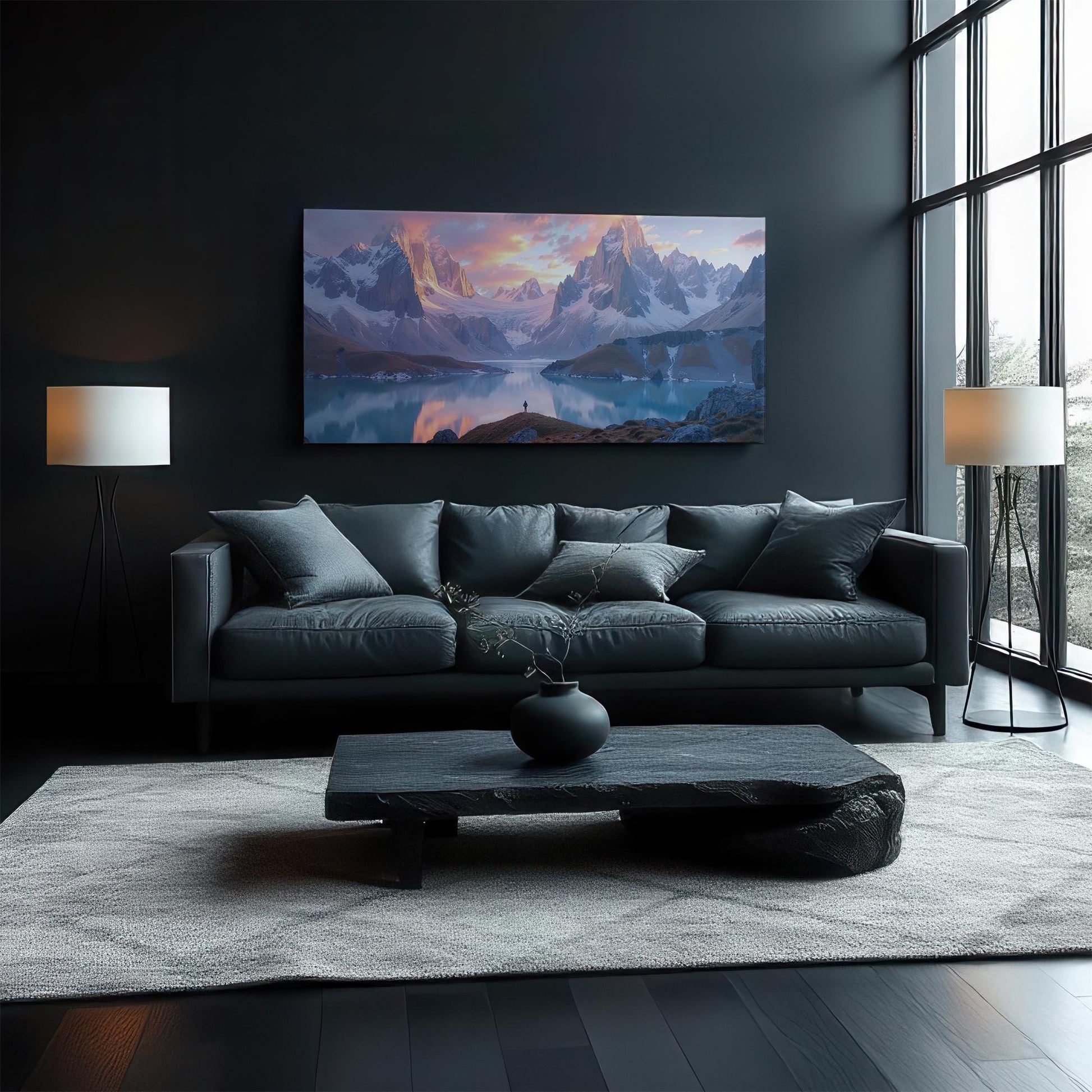 A stunning panoramic canvas print featuring majestic mountains and a glowing sunset reflection over a serene alpine lake. The warm golden tones contrast beautifully with the soft whites and cool blues of the peaks. Displayed in a bright, modern living room, this landscape art enhances the aesthetic with its tranquil yet powerful presence, making it a perfect centerpiece for nature lovers and adventure seekers.