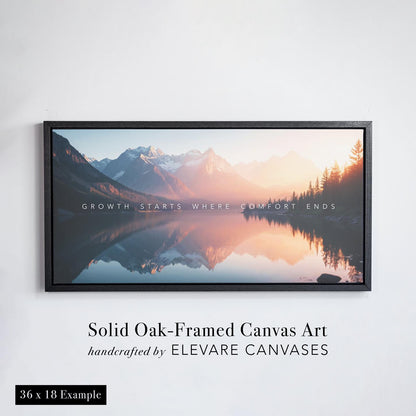Framed canvas wall art featuring a serene mountain landscape with a glassy lake reflecting snow-capped peaks and a glowing sunset. The artwork is presented in a solid oak floater frame with a bold profile, handcrafted by Elevare Canvases. The canvas displays the inspirational quote “Growth starts where comfort ends” across the center. This is a 36 x 24 inch example shown against a white wall.